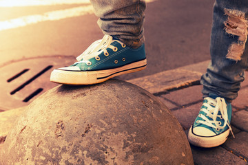 Blue sneakers, teenager feet in gumshoes, toned - obrazy, fototapety, plakaty