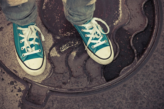 Teenager in sneakers. Feet in gumshoes, old style