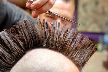 Barber cutting and modeling hair by scissors