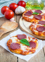 Homemade mini pepperoni pizza on a wooden board