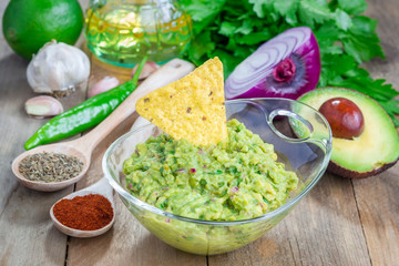 Bowl with chunky guacamole and ingredients