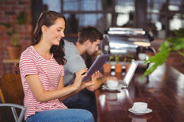 Smiling young woman using tablet computer