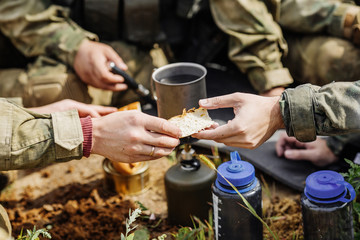 rangers are heated food on the fire and eat in the forest