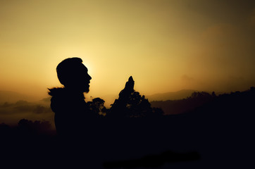 image silhouette a man standing and pray. dark and grain background.sunset and sunrise