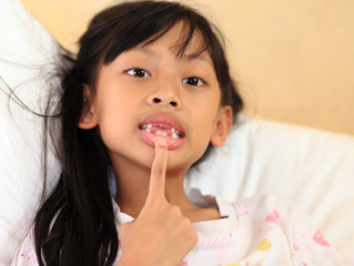 beautiful little girl grinning at the camera showing off her mis © alexzeer