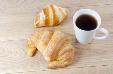 Breakfast cup of coffee and croissant.