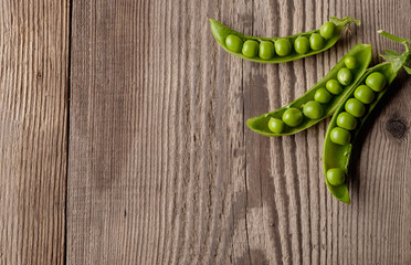 Ripe Green peas on wooden table.