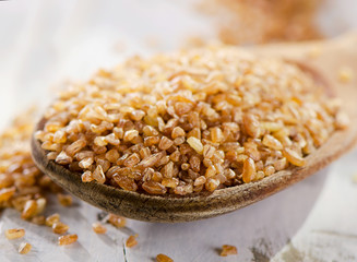Bulgur in  wooden spoon.