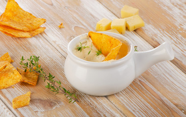 Cheese Sauce with Nachos on  wooden background.