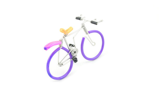 purple wired bicycle miniature moving foward isolated white background