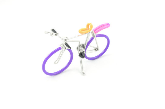 beautiful handcraft bicycle made from purple and grey wired places from right to left isolated white background