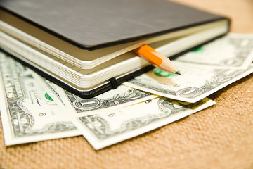 notebook, pencil and money on the old tissue