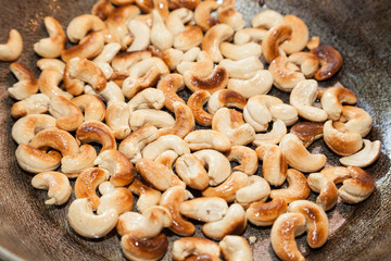 Closeup of roasted cashew on frying pan with selective focus