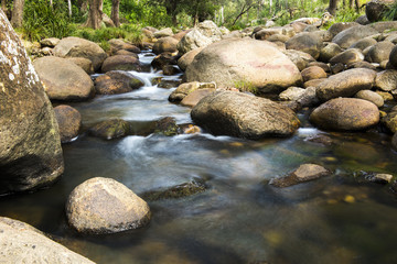 Rocks and flowing water in a creek bed at the base of the mountain Spicers Gap, Queensland, Australia. 