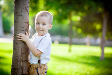 boy hiding behind a tree
