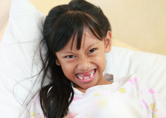 beautiful little girl grinning at the camera showing off her mis © alexzeer