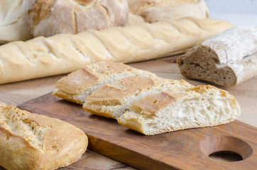 Sliced bread on an olive wooden board.