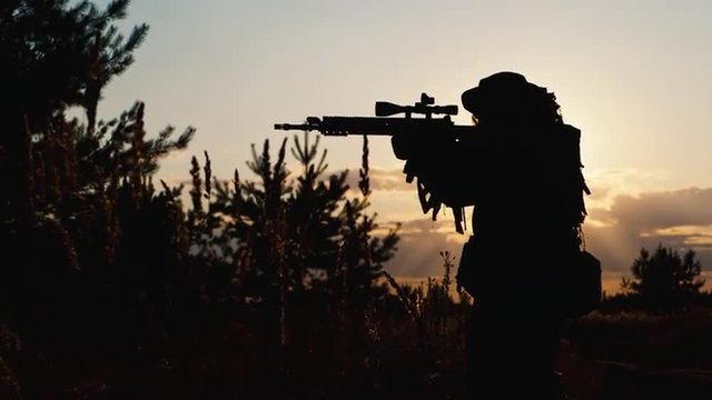 Silhouette of a soldier who takes aim