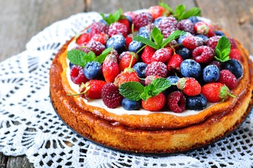 Cottage cheese casserole with fresh strawberries, blueberries, raspberries and mint and powdered sugar