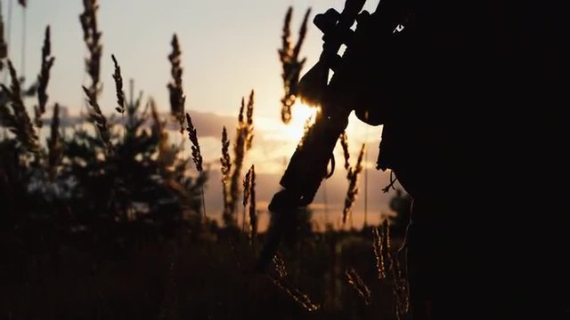 Silhouette of a soldier who takes aim