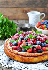 Cottage cheese casserole with fresh strawberries, blueberries, raspberries and mint and powdered sugar