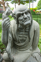 old man stone statue in garden