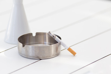 Cigarette in ashtray on the table