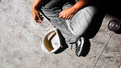 Male money beggar with hat and coffee cup