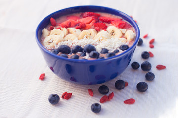 strawberry-banana smoothie bowl topped with acai, blueberries, strawberries, bananas and coconut 