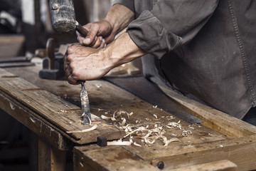 Carpenter with a hammer and chisel - obrazy, fototapety, plakaty