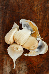 Cloves of raw garlic on a dark chopping board