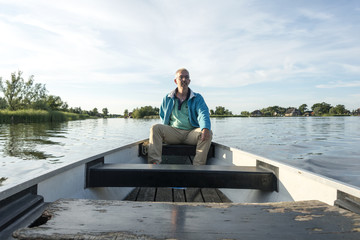 man in wooden boat on the lake