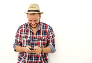 Trendy happy guy with hat looking at mobile phone