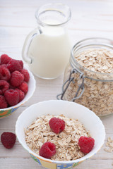 Berries, fruit, milk and muesli Ingredients for healthy breakfast on wooden table