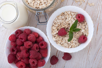 Berries, fruit, milk and muesli Ingredients for healthy breakfast on wooden table