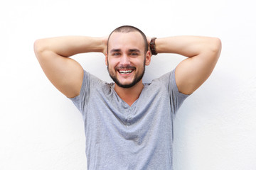 Handsome young man smiling with hands behind head