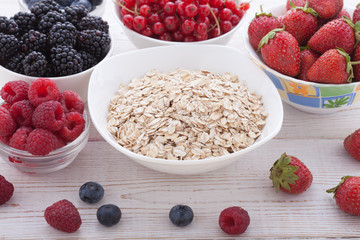 Breakfast - berries, fruit and muesli on white wooden