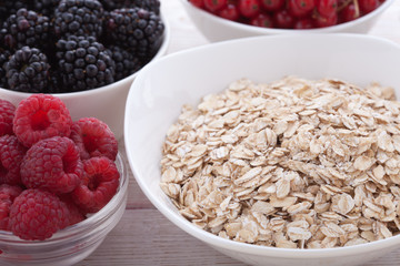 Breakfast - berries, fruit and muesli on white wooden
