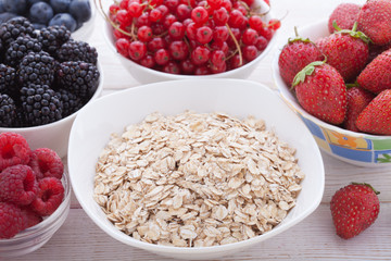 Breakfast - berries, fruit and muesli on white wooden