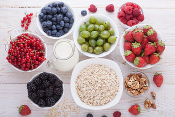 Breakfast - berries, fruit and muesli on white wooden