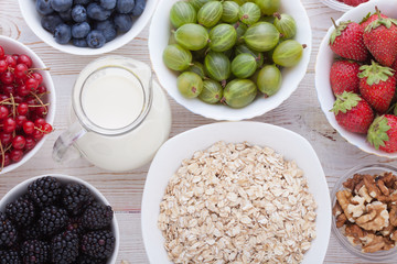 Breakfast - berries, fruit and muesli on white wooden