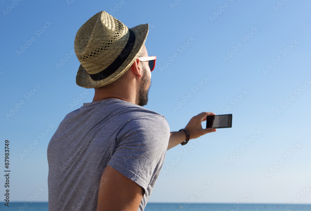 Sticker young man taking selfie by the sea