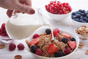 Breakfast - berries, fruit and muesli on white wooden