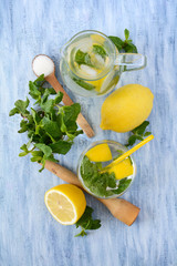 Homemade classical lemonade with mint and lemons on blue wooden background
