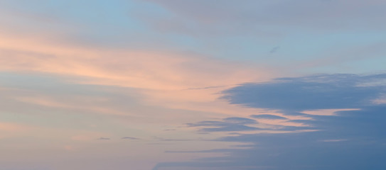 Fototapeta premium Blue sky with fluffy colored clouds, ray of lights, sunset, dawn.