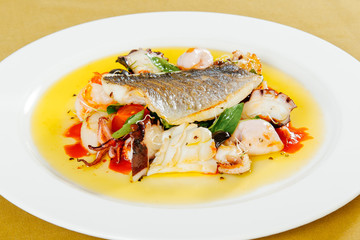 Fototapeta na wymiar Dorado with seafood and cherry tomatoes on a white plate