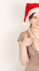 Junge Dame mit Weihnachtsmann Mütze und Daumen hoch