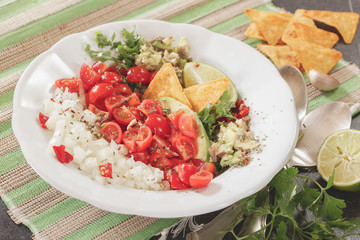 Pico de gallo and nacho chips on rustic table background