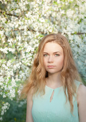Naklejka premium Beautiful girl in the blooming garden
