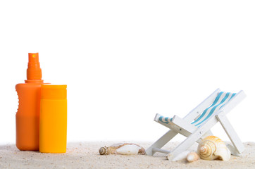 strandliege, sonnencreme und muscheln auf sand